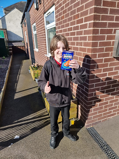 Child smiling with chocolate biscuits outside home