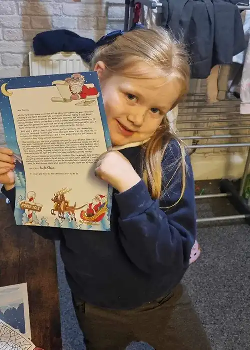 Child holding a letter from Santa Claus.